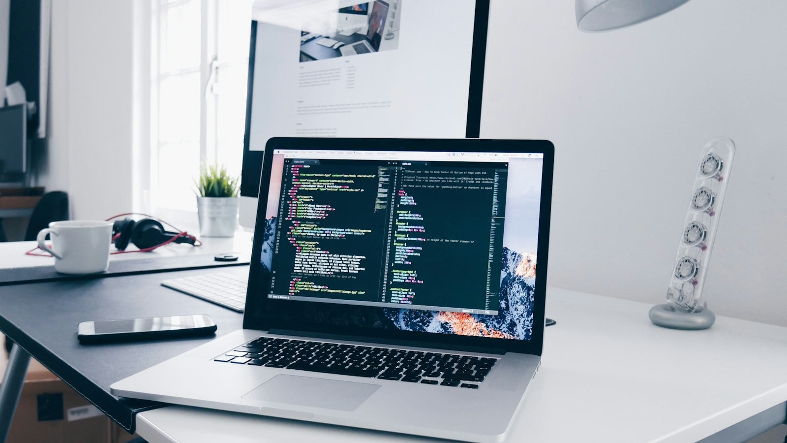 Laptop with code on a tidy developer desk (photo: Christopher Gower / Unsplash)